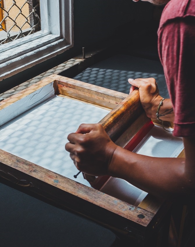 A boy doing screen printing.